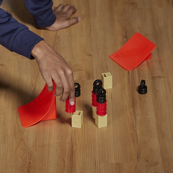 Installation des tas de pneus, des bidons, des bottes de foin et des deux rampes de propulsion par un enfant sur le parquet en bois d'une pièce