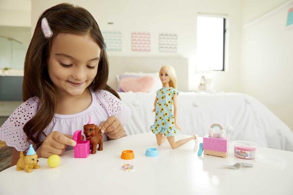 Fille s'amuse avec Barbie et ses chiots