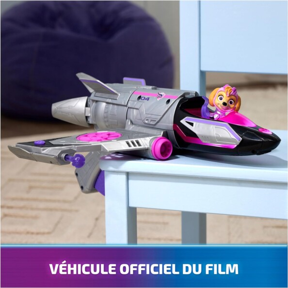 Véhicule officiel du film La Pat' Patrouille : La Super Patrouille Le Film et sa figurine Stella posés sur une table en bois dans une pièce avec parquet au sol