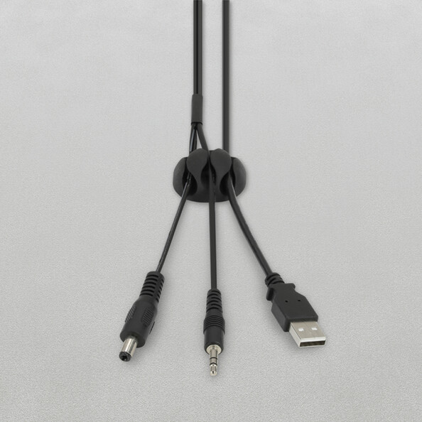 Passe-câbles à 3 fentes installé sur une surface blanche et organisant trois câbles différents