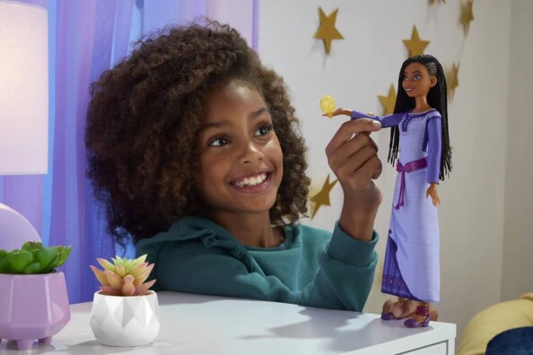 Fille bouge le bras de la poupée Asha pour qu'elle chante