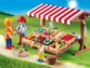 Mise en situation de l'étal de légumes sur un chemin de terre avec trois figurines en plastique Playmobil