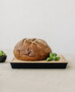 Planche en chêne avec miche de pain rustique en mise en scène