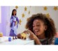 Jeune petite fille qui rigole appuyant sur la chèvre mobile qui tire la langue du coffret voyage avec poupée Asha