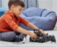 Enfant enferme les Super-vilains dans la cellule grillagée à l'arrière de la Batmobile