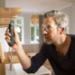 Homme en lunettes vissant avec la visseuse Bosch PushDrive au-dessus d’un plan de travail